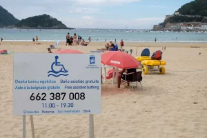 Cartel de baño asistido gratuito en la playa de La Concha